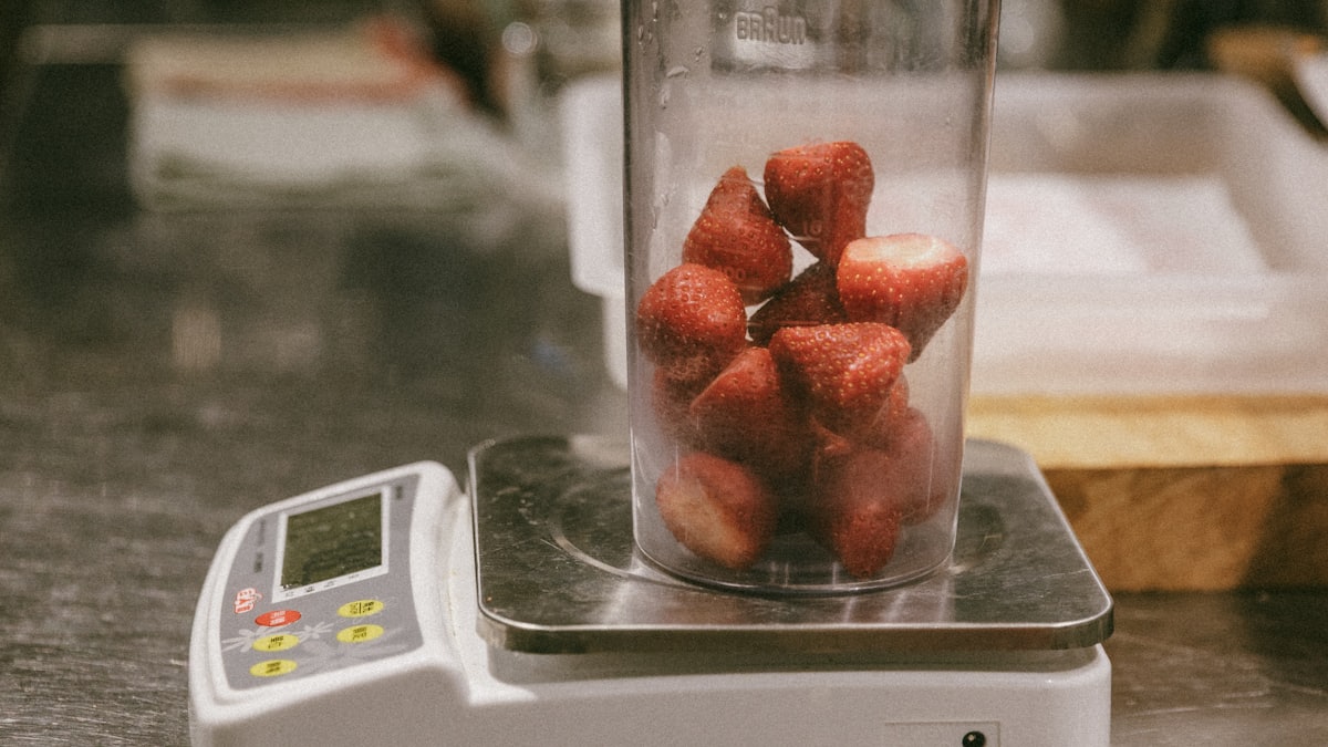Chef weighing ingredients on a kitchen scale to cost a recipe