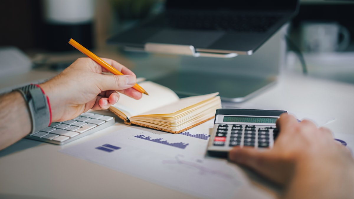 Supplier reviewing a khata ledger of outstanding accounts