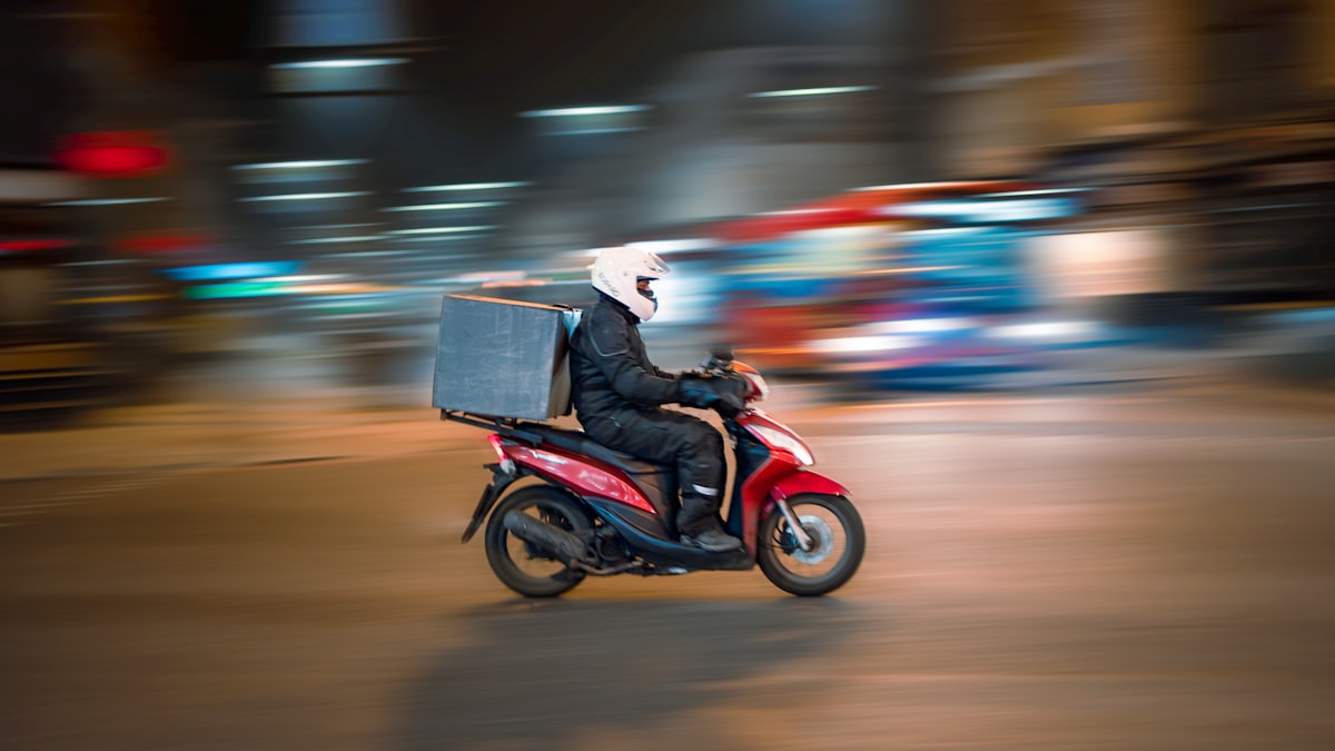 Food delivery rider with an insulated bag on a scooter